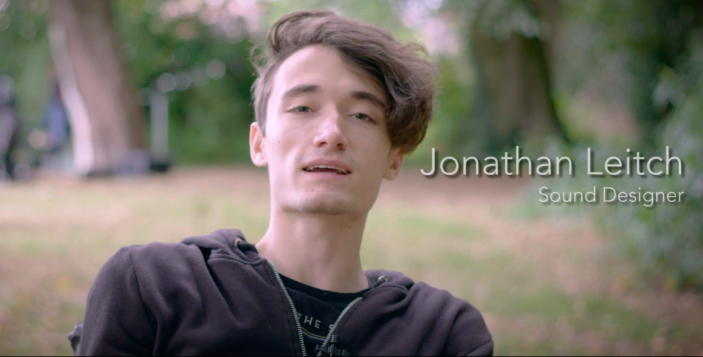 Screengrab of Jonny being interviewed in the park setting of Inside Out Festival in Shelley Park. His name and title are on the screen to the right and it says Jonathan Leitch, Sound Designer